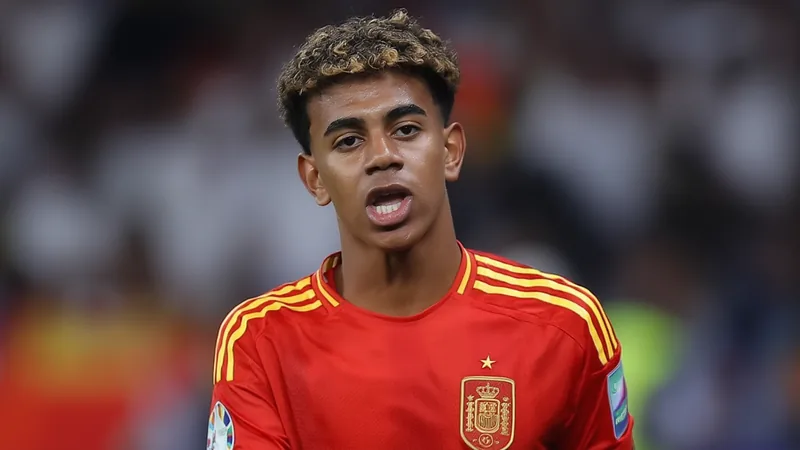 Lamine Yamal, jovem atacante do Barcelona, sorrindo com a camisa da seleção espanhola em campo de futebol — latest news and analysis.