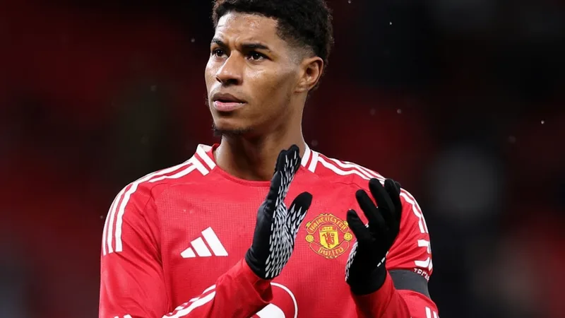 Marcus Rashford vestindo o uniforme do Manchester United, com o estádio Old Trafford ao fundo, durante um jogo noturno. — latest news and analysis.