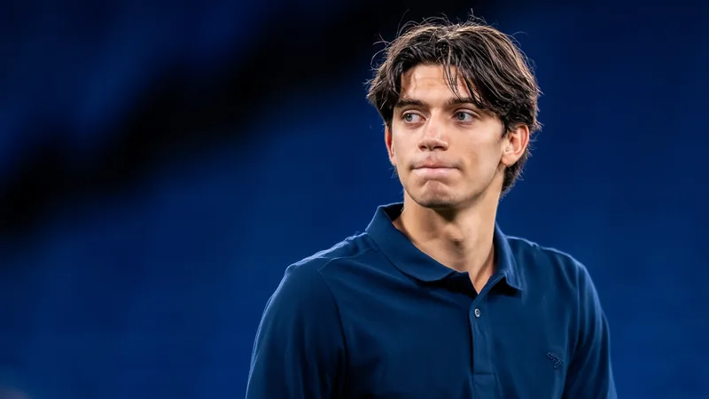 Jovem jogador de futebol italiano, Marco Palestra, vestindo a camisa do Atalanta, em campo durante uma partida, com expressão concentrada.