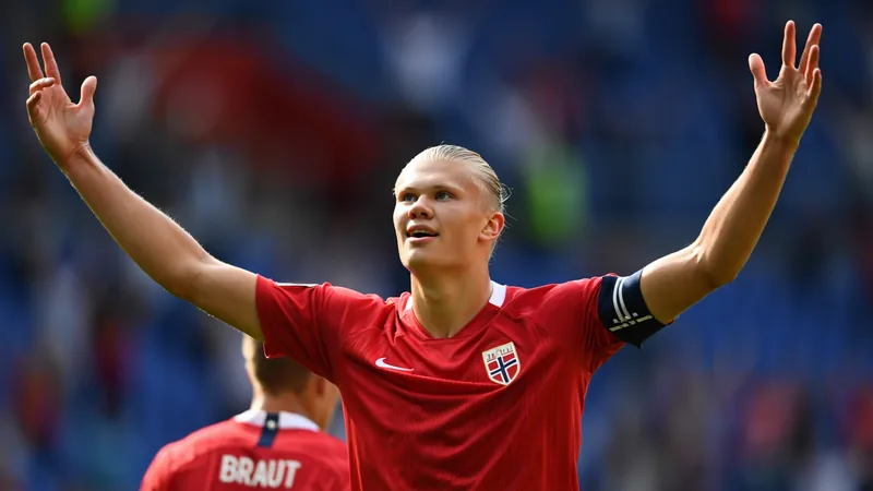 Erling Haaland vestindo a camisa da seleção norueguesa com o nome 'Braut' visível, sorrindo em campo durante uma partida internacional.