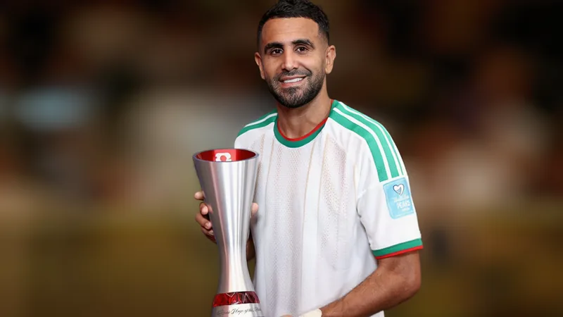 Riyad Mahrez com a camisa da Argélia segurando o prêmio de Melhor em Campo no Estádio 5 de Julho de 1962, em Argel, durante o amistoso contra a