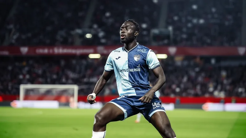 Jogador Arouna Sangante, defesa-central senegalês, com a camisola do Le Havre durante uma partida da Ligue 1, em ação defensiva contra um atacante