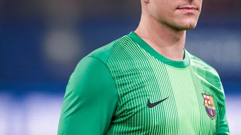 Guarda-redes Marc André ter Stegen com equipamento do Barcelona, em ação num jogo noturno, com o estádio iluminado ao fundo