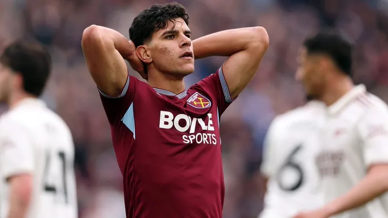 Jogador Mateus Fernandes com a camisa do West Ham United em campo, durante uma partida da Premier League, com torcida ao fundo.