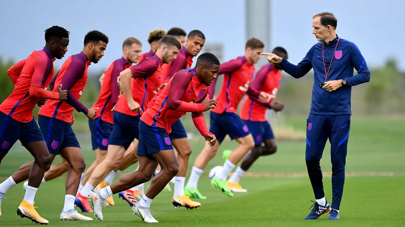 Tuchel não tem medo de gritar com jogadores, diz Watkins — Football Thomas Tuchel gritando instruções durante um treino da seleção inglesa em campo gramado, com jogadores ao fundo concentrados.