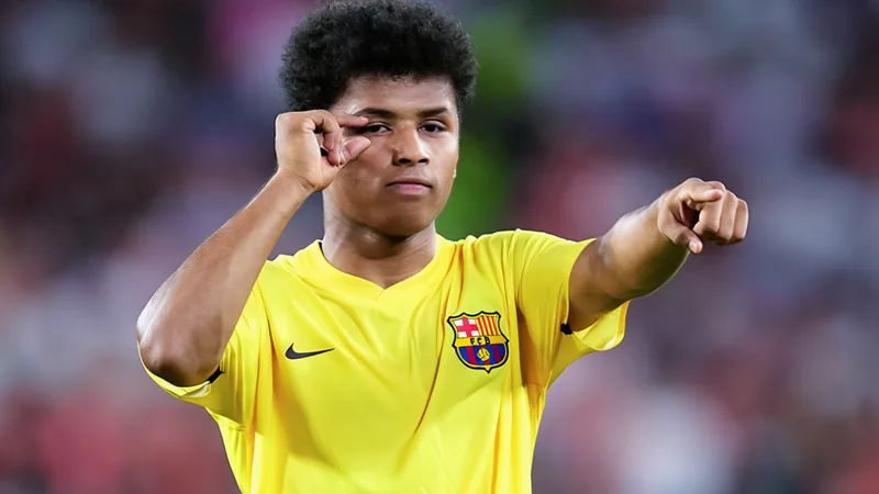 Jogador Karim Adeyemi com a camisa do Barcelona em frente ao Camp Nou, sorrindo e segurando uma bola de futebol. — latest news and analysis.