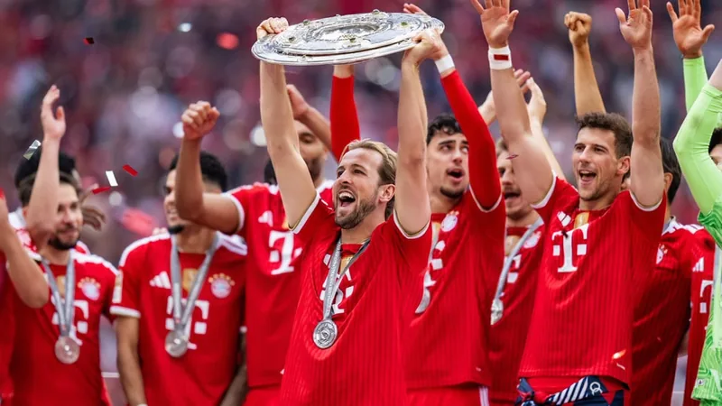 Harry Kane com a camisa do Bayern de Munique comemora um gol em partida da Bundesliga, com torcida ao fundo. — latest news and analysis.