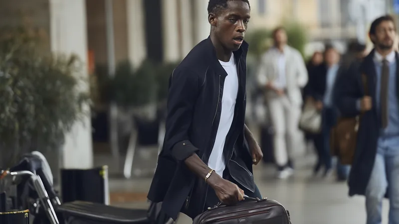 Eddy Kouadio chega a Milão para fechar empréstimo ao Monza — Football Eddy Kouadio, jovem médio ofensivo, posa para foto com cachecol do Monza no aeroporto de Milão, com avião ao fundo. — latest news and analysis.