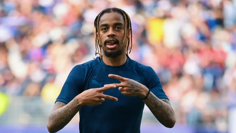 Bradley Barcola, atacante francês do Paris Saint-Germain, em ação durante uma partida, com a camisa do clube e fundo do estádio.