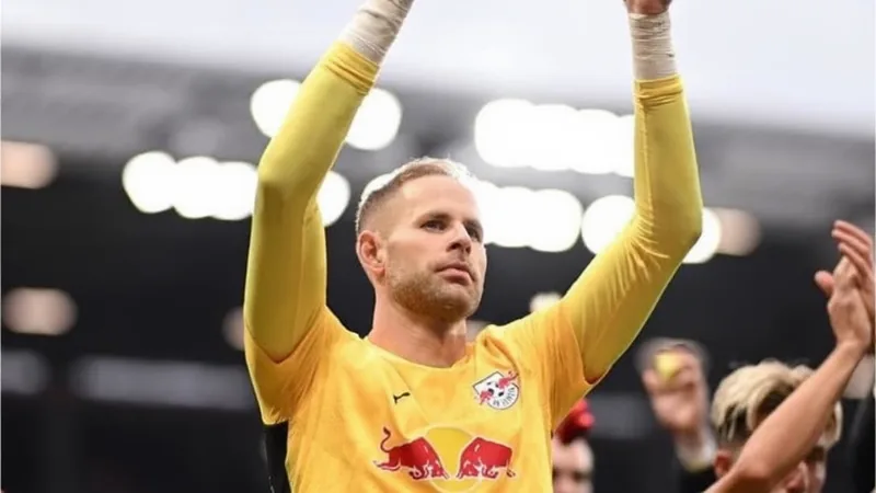 Peter Gulacsi, goleiro húngaro, vestindo o uniforme do RB Leipzig, em ação durante uma partida, com o estádio ao fundo. — latest news and analysis.
