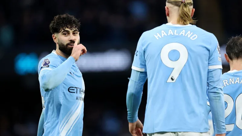 Josko Gvardiol com a camisola do Manchester City a segurar uma caneta e um contrato, ao lado do logótipo do clube, num ambiente de escritório moderno.