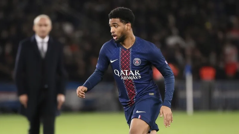 Ibrahima Mbaye deixa PSG no verão; Jorge Mendes comanda futuro Jovem jogador de futebol senegalês com camisola do PSG a sair de campo, com o agente Jorge Mendes ao fundo em conversa com dirigentes.