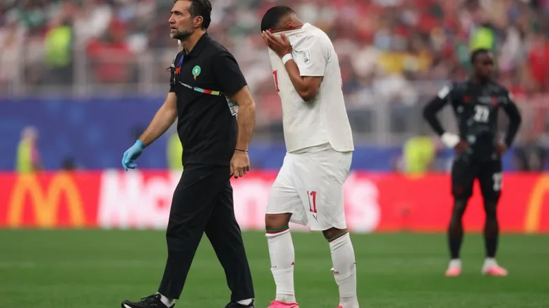 Lesão muscular tira Ismael Saibari do jogo contra o Canadá — Football Jogador marroquino Ismael Saibari caído no gramado do Estádio de Marrakech segurando a coxa direita, com equipe médica se aproximando.