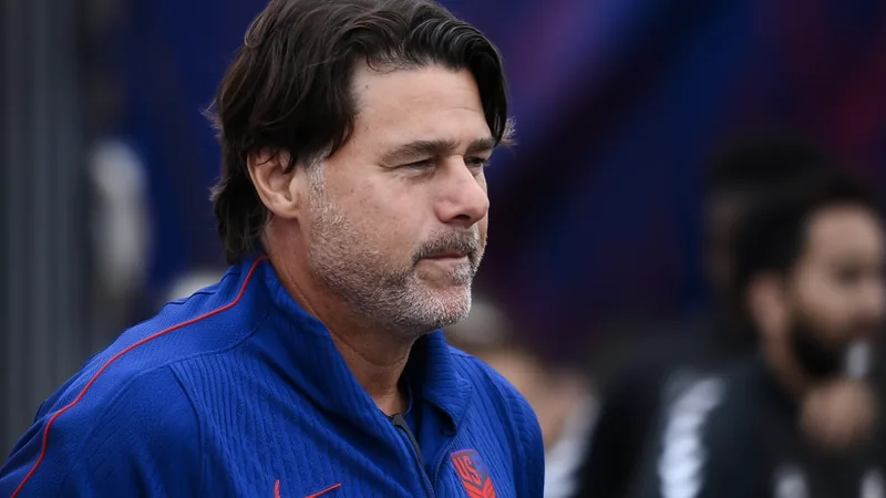 Mauricio Pochettino, técnico argentino, sorrindo em coletiva de imprensa com a camisa da seleção dos Estados Unidos ao fundo.
