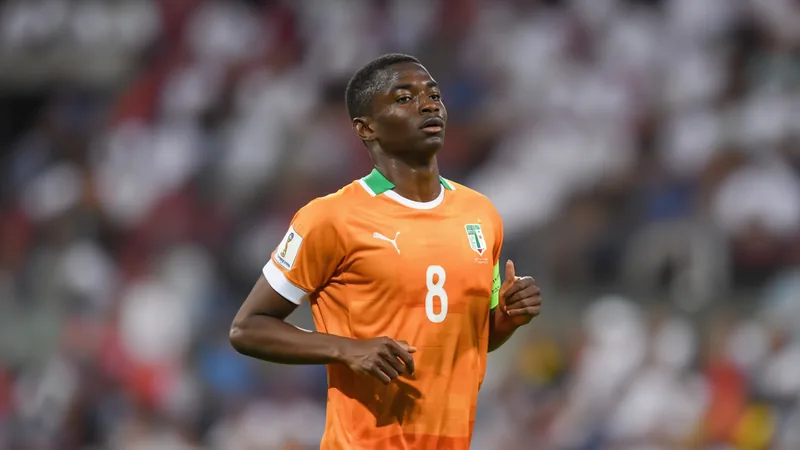 Newcastle United fecha acordo com Hoffenheim por Bazoumana Touré Jovem jogador marfinense Bazoumana Touré com a camisa do Hoffenheim em campo, sorrindo e segurando uma bola de futebol. — latest news and analysis.