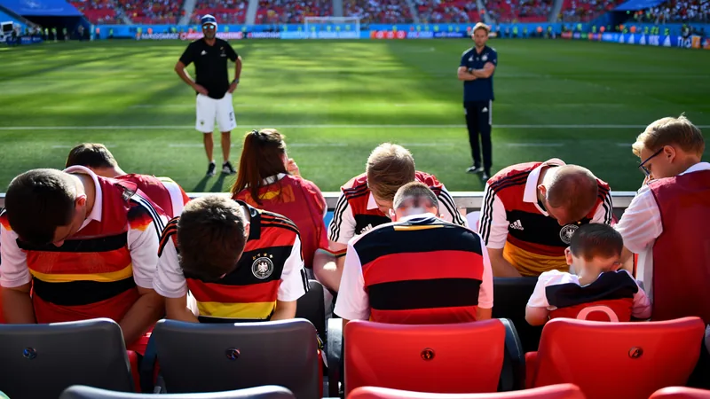 Torcedores alemães buscam esperança enquanto Klopp se aproxima Torcedores alemães com bandeiras e rostos preocupados em um estádio, com Jürgen Klopp sorrindo ao fundo em um telão. — latest news and analysis.