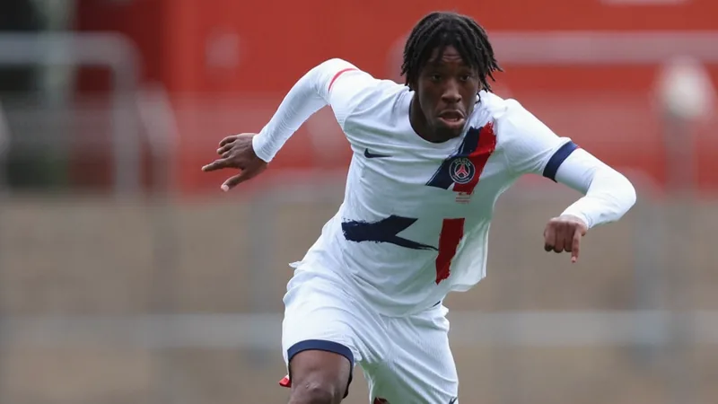 Transferência de Hermann Malonga para o Manchester City é cancelada Jovem futebolista Hermann Malonga em campo, vestindo a camisa do seu clube atual, com expressão séria, enquanto ao fundo vê-se o estádio do