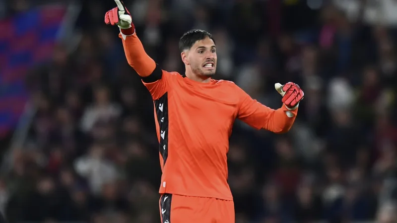 Goleiro Federico Ravaglia com uniforme do Bologna em campo, segurando a bola, com arquibancada ao fundo — latest news and analysis.