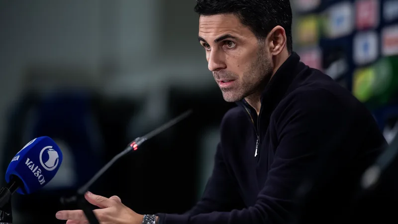 Arteta: "A ambição do clube é grande e queremos evoluir o plantel" Mikel Arteta, treinador do Arsenal, em conferência de imprensa, com o emblema do clube ao fundo, falando sobre a ambição de evoluir o plantel.
