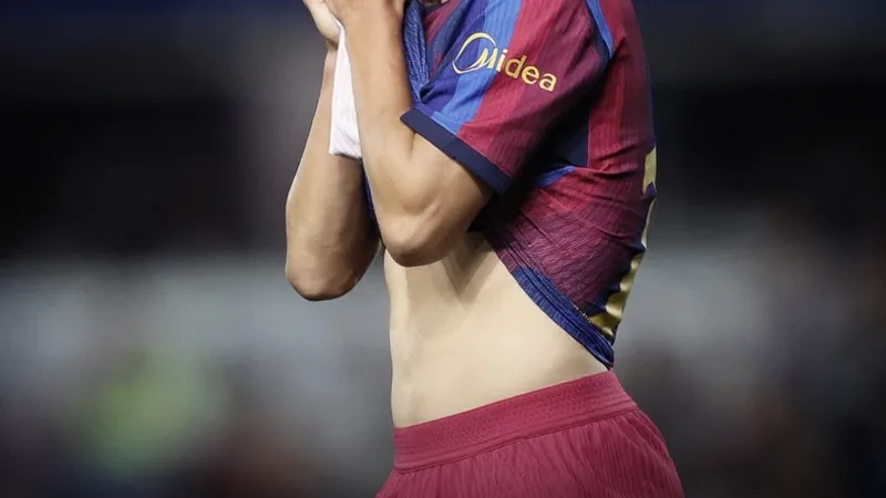 Bardghji sofre lesão grave e desfalca Barcelona — Football World Cup Jovem jogador de futebol sueco com uniforme do Barcelona sentado no gramado, segurando o joelho, com expressão de dor, enquanto equipe médica se