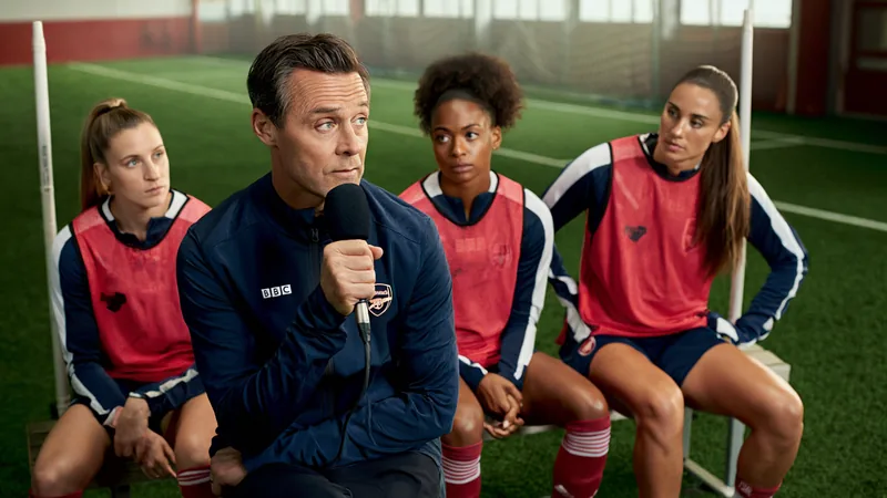 BBC Futebol Feminino: Arsenal em destaque — Football World Cup News Centro de treinamento do Arsenal em London Colney com jogadoras de futebol feminino em campo, incluindo Georgia Stanway e Ona Batlle, sob luz natural.