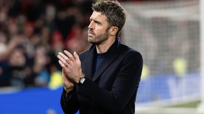 Michael Carrick, treinador do Middlesbrough, a falar numa conferência de imprensa, com o logótipo do clube ao fundo e um microfone à sua frente.