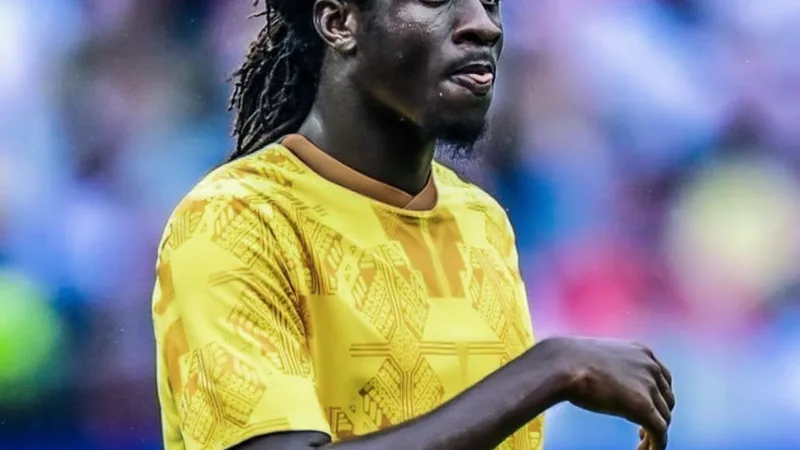Caleb Yirenkyi, jogador ganês de 21 anos, com a camisola do Nordsjælland, em ação num campo de futebol, com adeptos ao fundo.