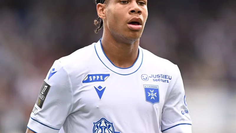 Jovem meio-campista Kevin Danois com a camisa do Auxerre em campo, durante partida da Ligue 1, com estádio ao fundo. — latest news and analysis.