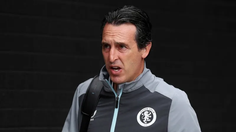 Unai Emery, treinador do Aston Villa, a falar numa conferência de imprensa, com o logótipo do clube ao fundo e um microfone à sua frente.