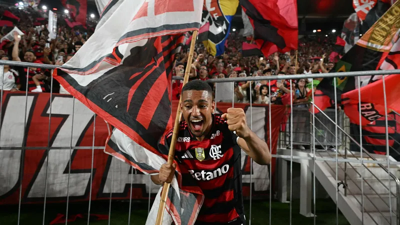 Samuel Lino, atacante do Flamengo, comemora um gol no Maracanã, vestindo o uniforme rubro-negro, com a torcida ao fundo.
