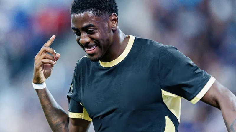 Southampton acerta empréstimo de Mubama — Football World Cup News Jovem atacante Divin Mubama com a camisa do Manchester City durante treino, em campo de futebol ao ar livre, com gramado verde e sol.