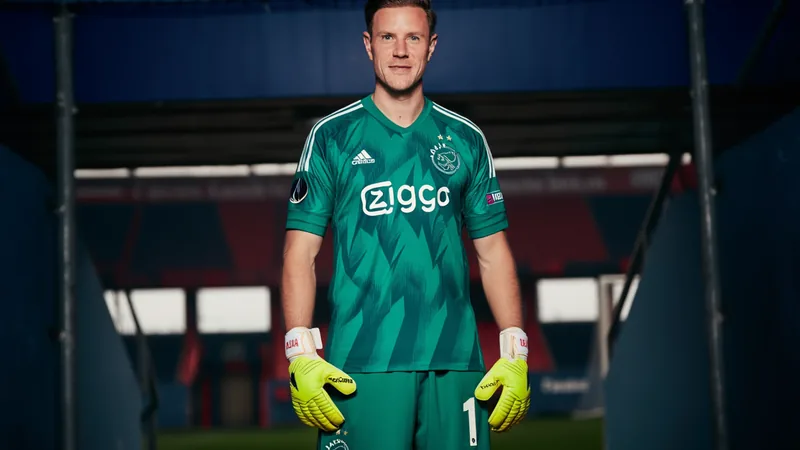 Ter Stegen Reforça Ajax por Empréstimo do Barcelona — Football World Marc-André ter Stegen vestindo a camisola do Ajax durante a apresentação oficial no estádio Johan Cruijff ArenA, em Amesterdão, com adeptos ao fundo.